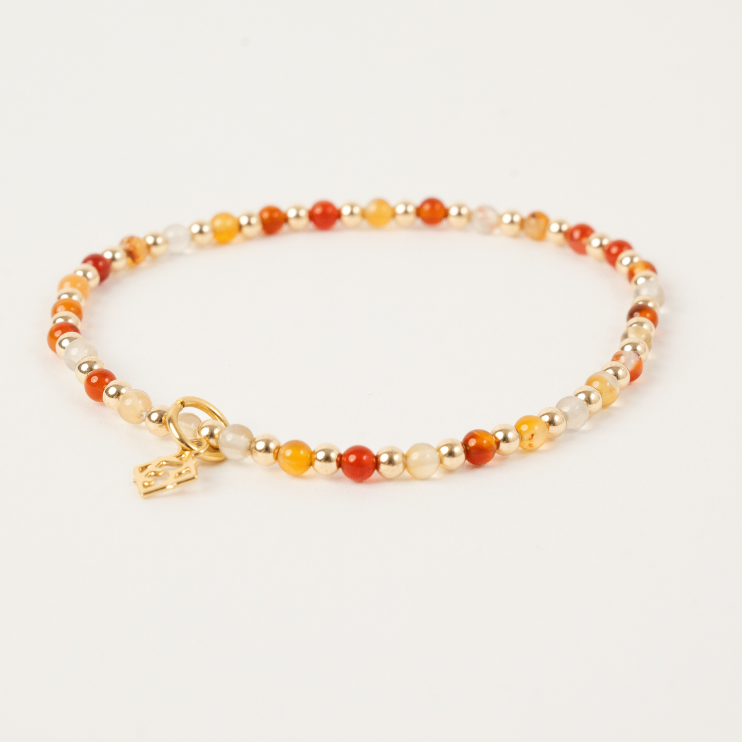 Beaded bracelet with gold clasp on a light background