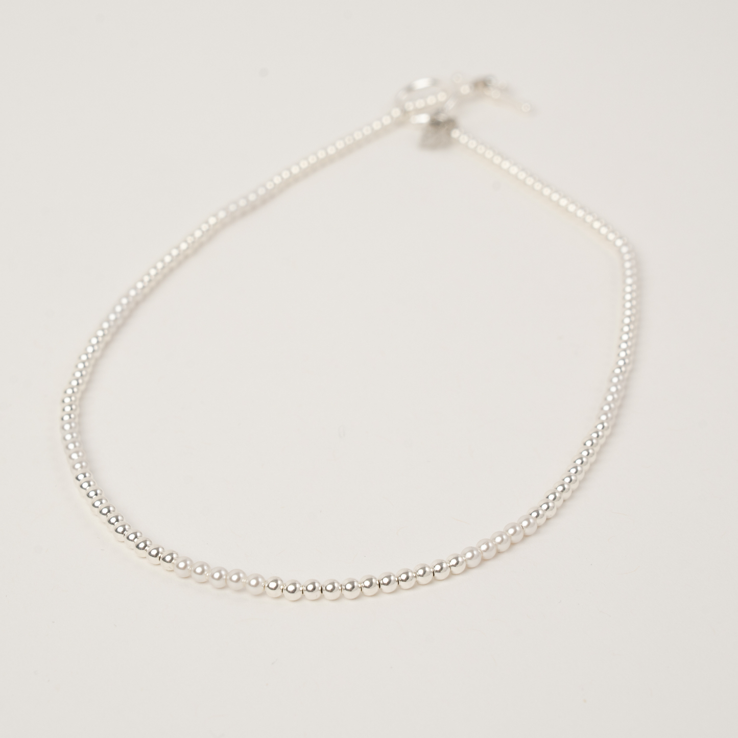 Pearl necklace on a light gray background