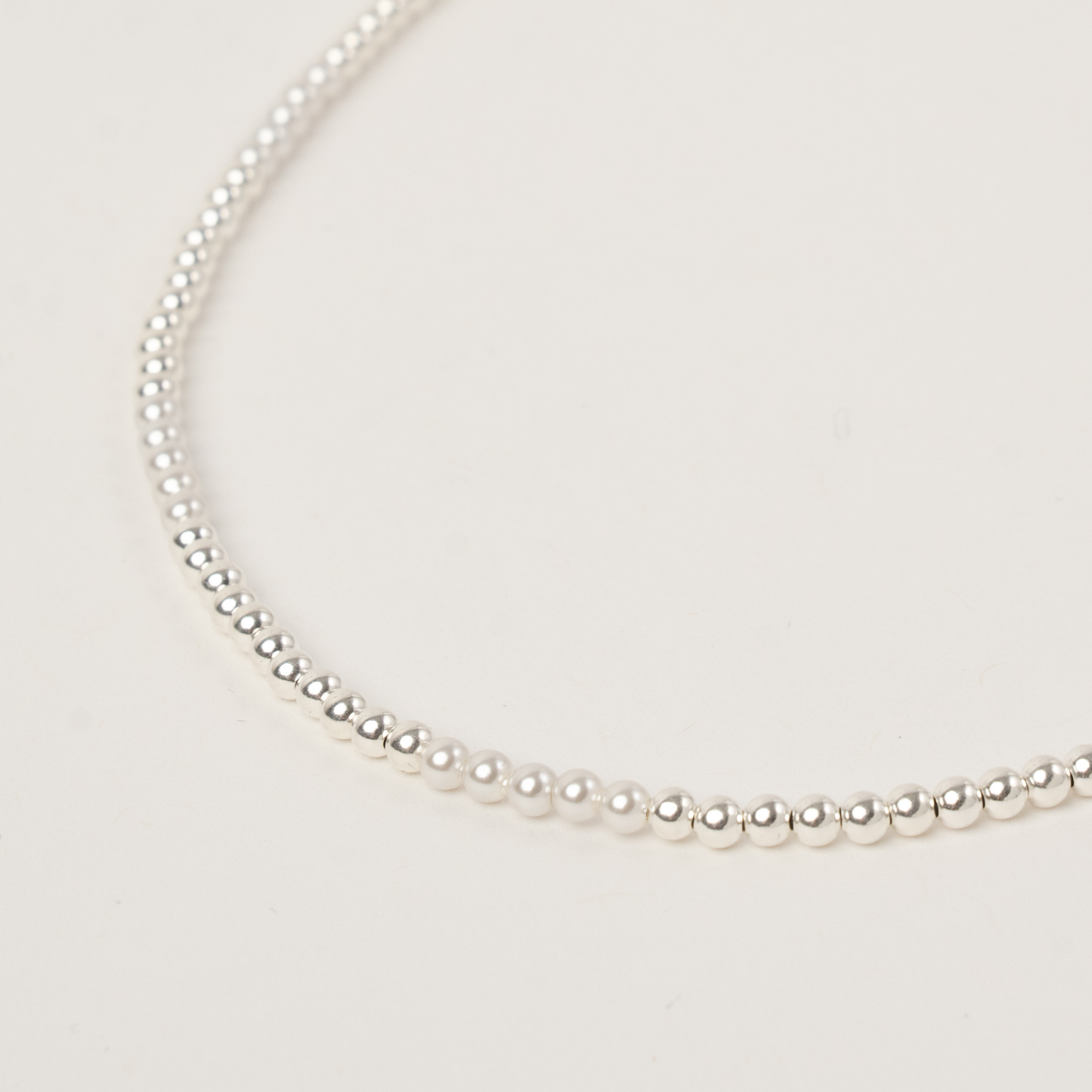 Pearl necklace on a light gray background