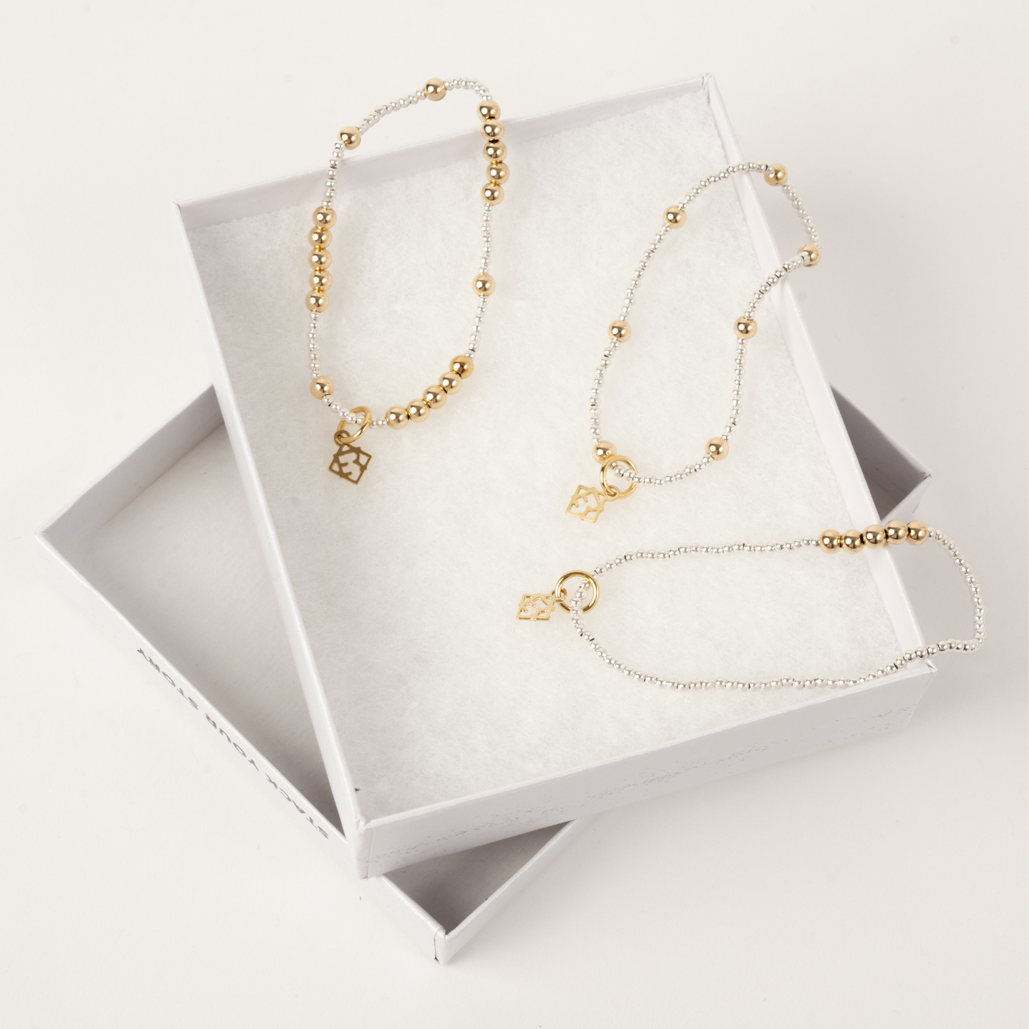 Gold beaded necklace on a white jewelry display box
