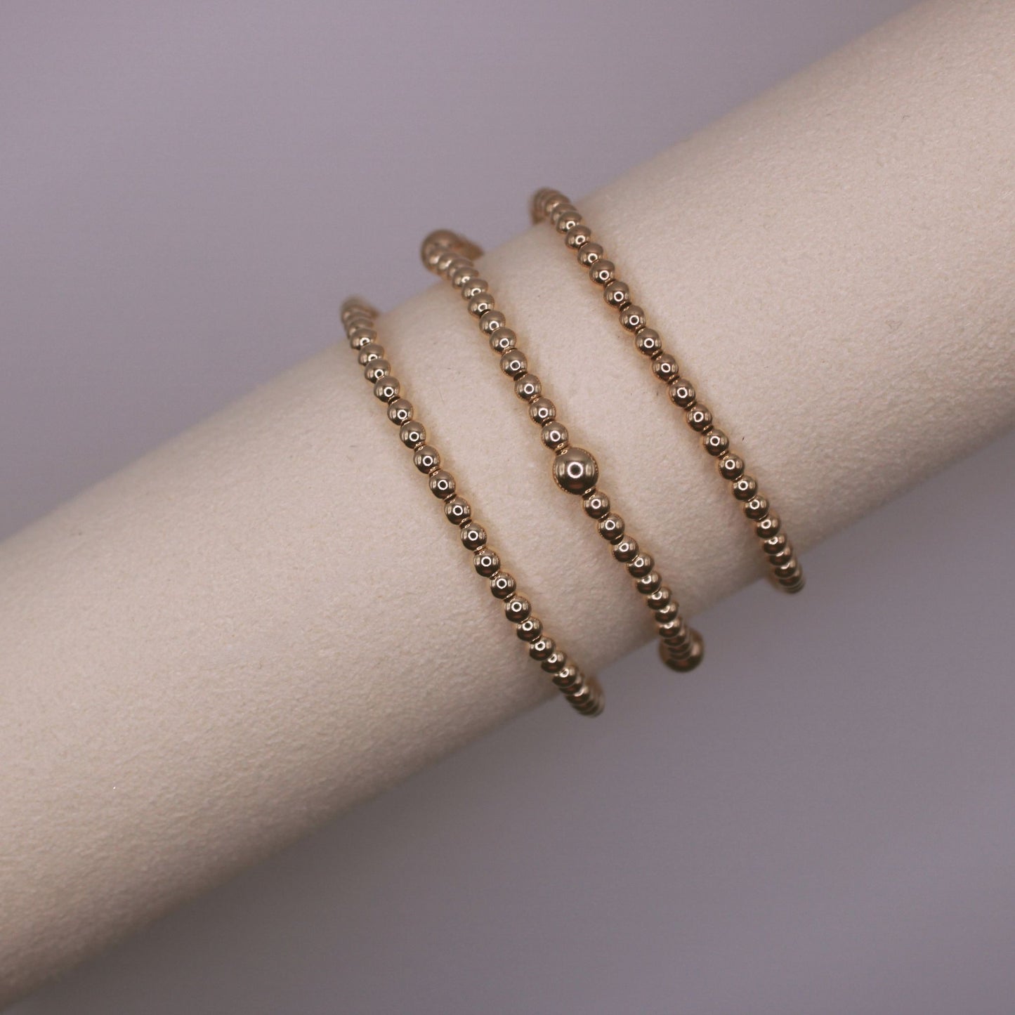 three gold beaded bracelets