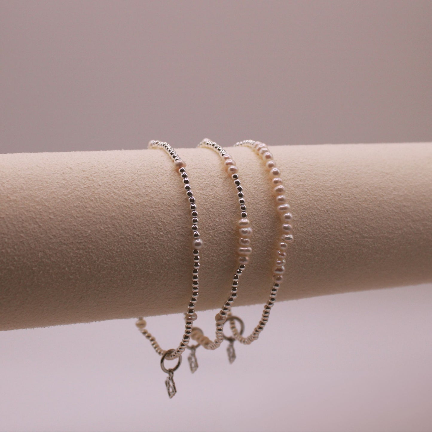trio of silver bracelets with pearl accents