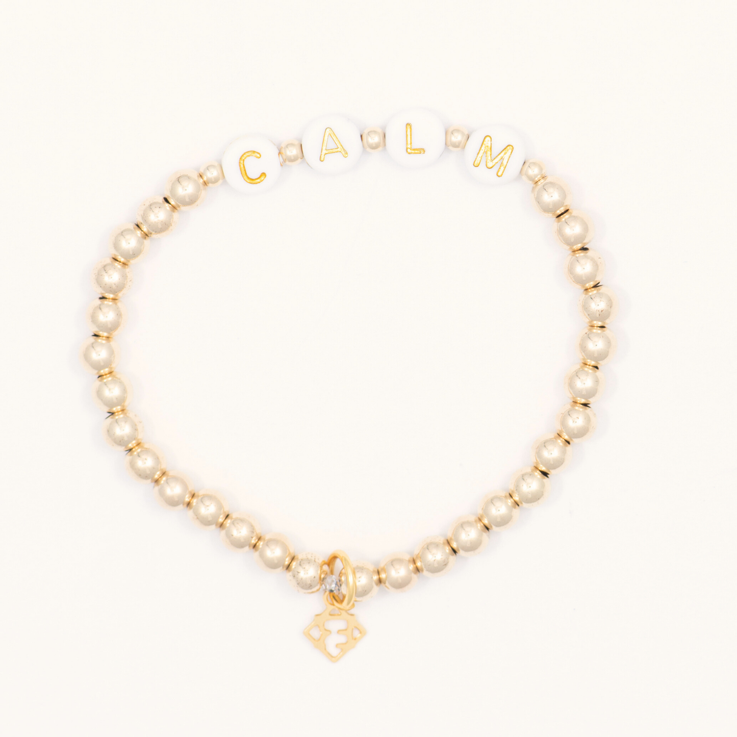 Beaded bracelet with gold accents and 'Carmen' charm on a white background