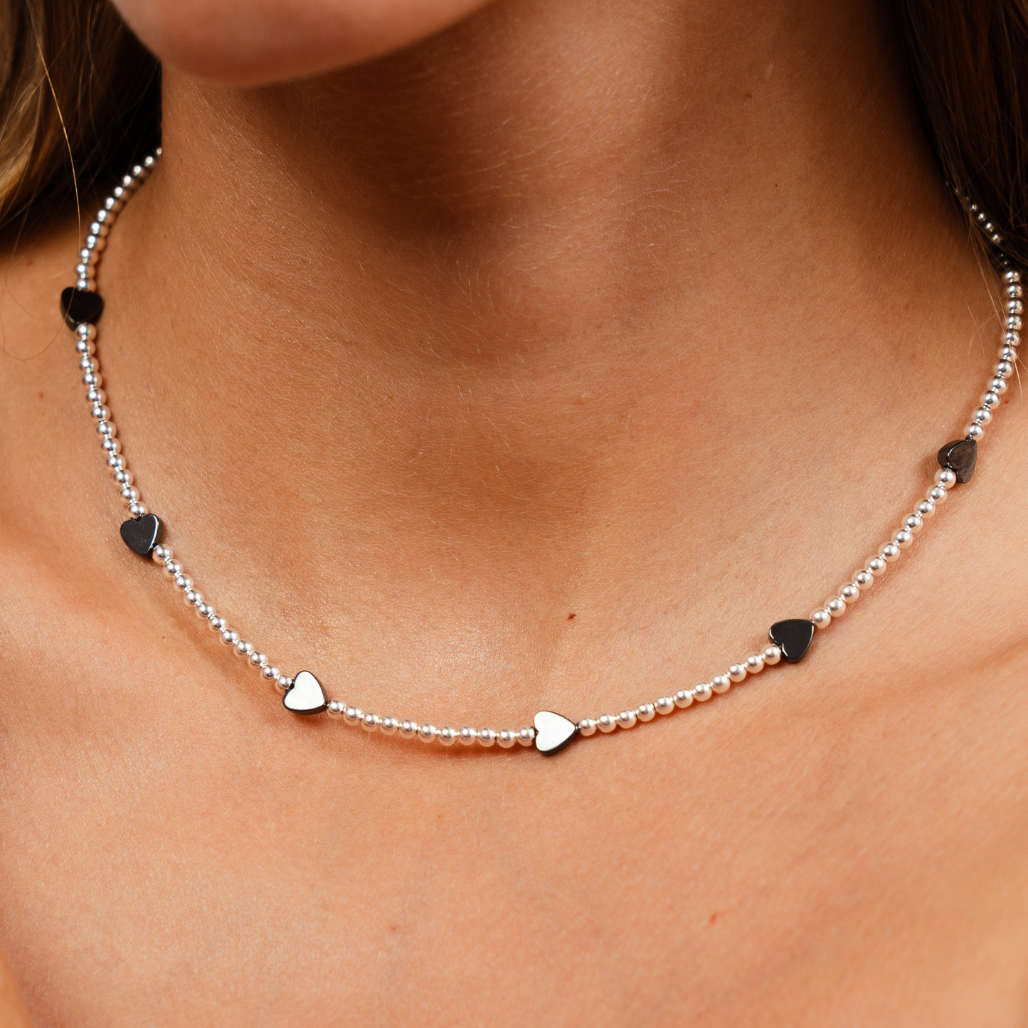 Necklace with heart-shaped pendants on a person's neck