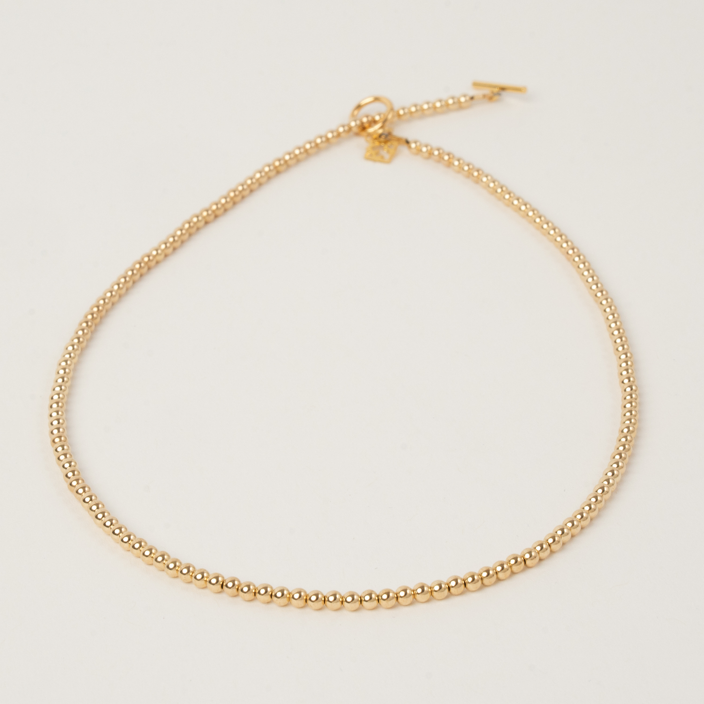 Gold necklace on a light gray background