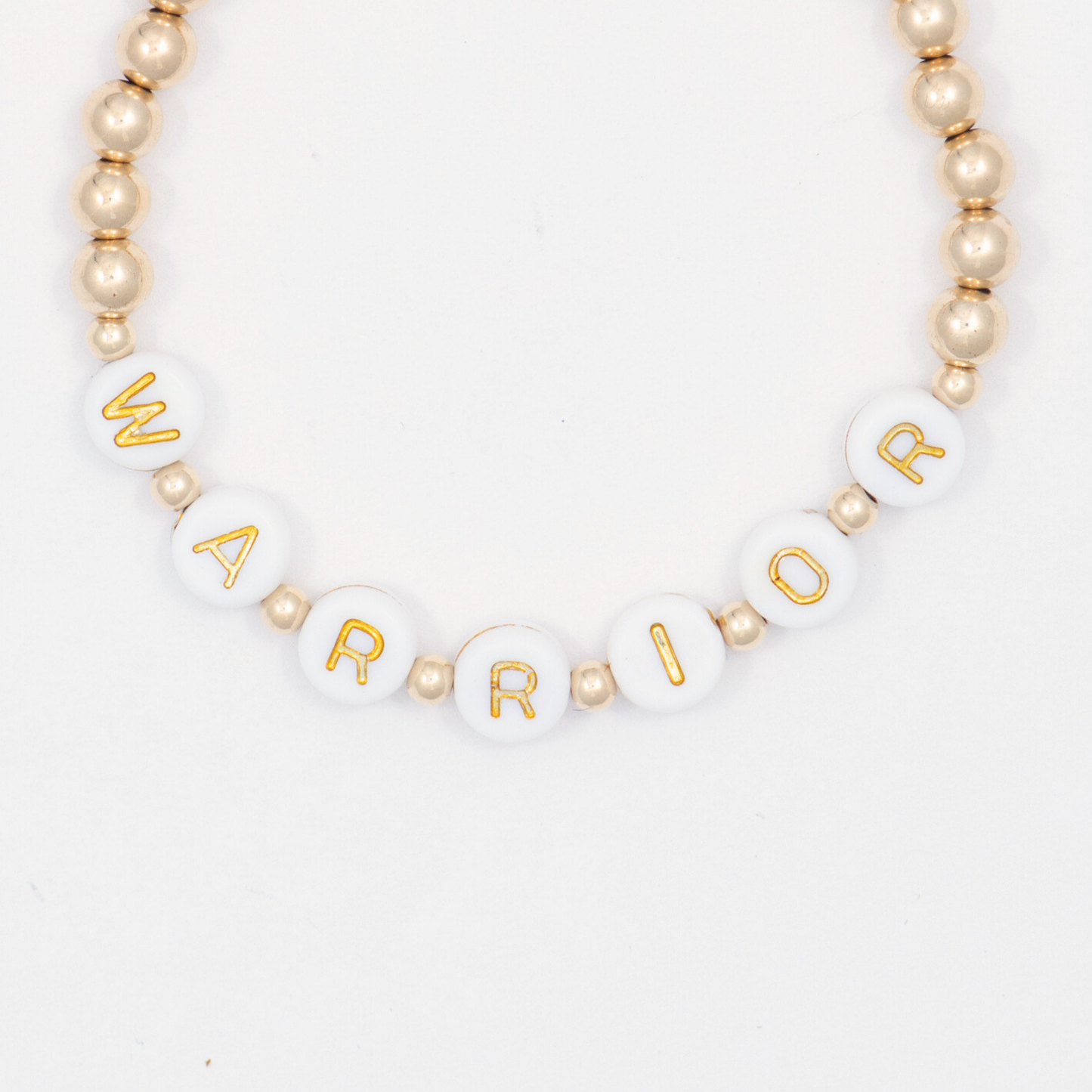 Bracelet with white beads and gold lettering spelling 'WARRIOR' on a white background