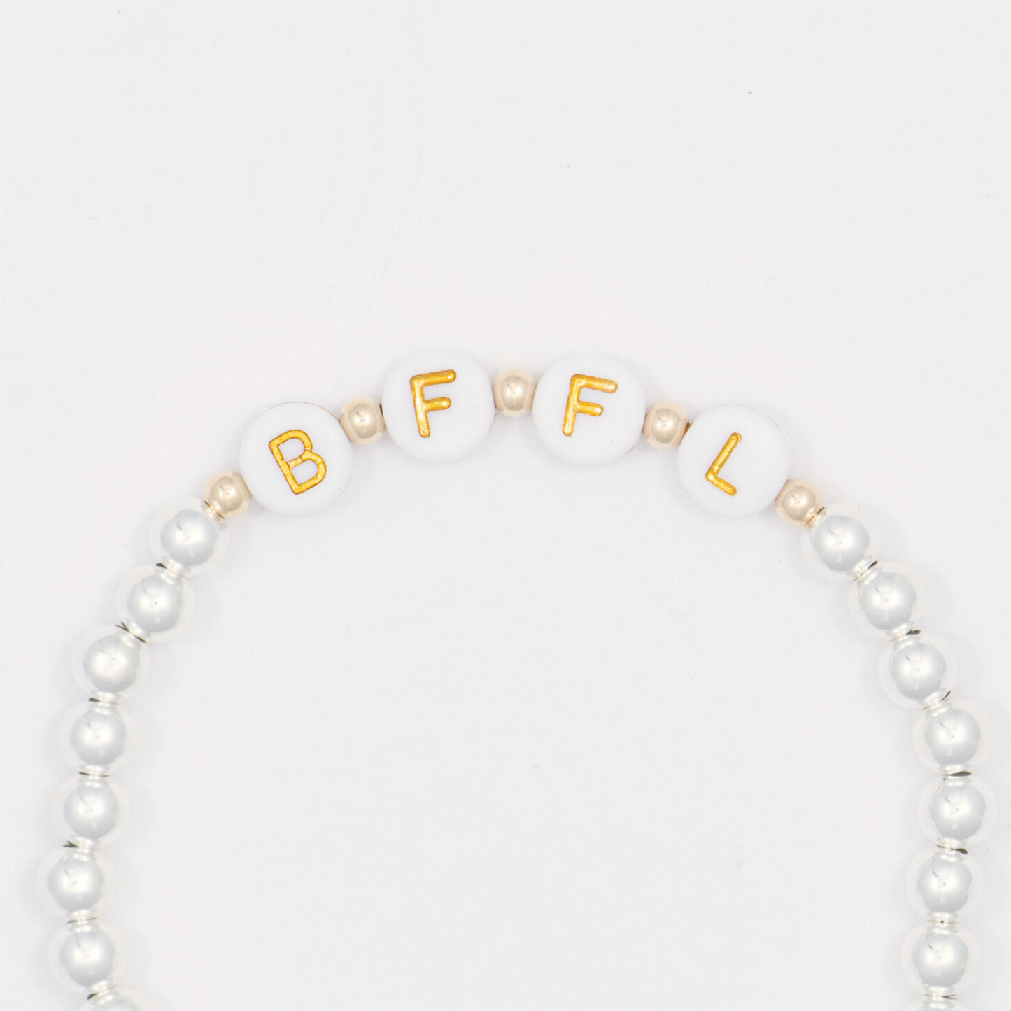 Beaded bracelet with gold letters spelling 'BFFL' on a white background