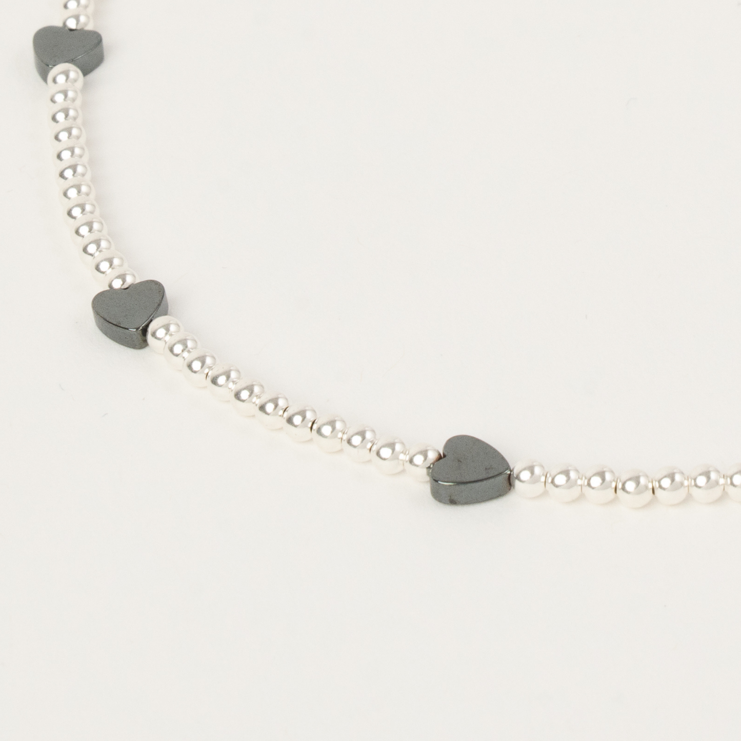 Necklace with heart-shaped charms on a light gray background