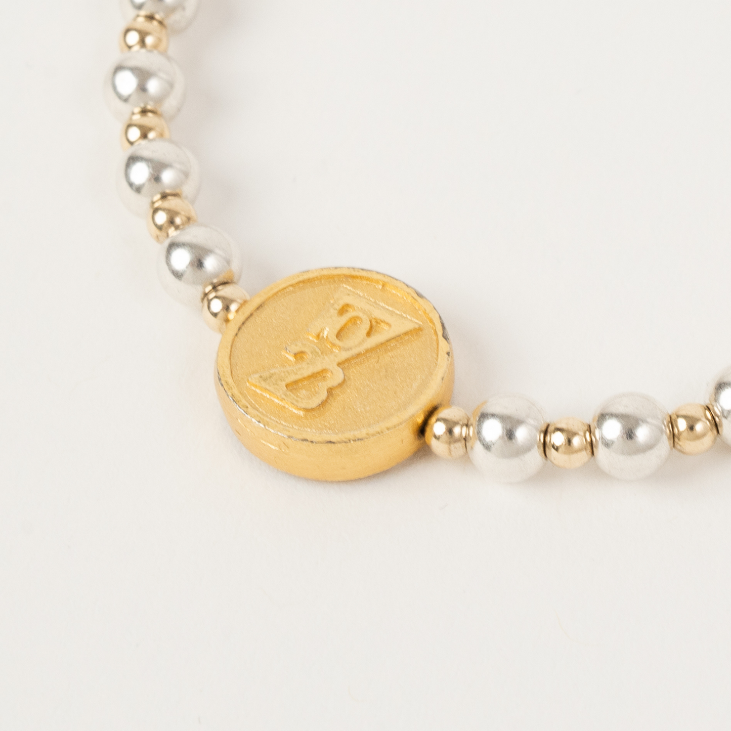 Bracelet with gold and silver beads on a white background