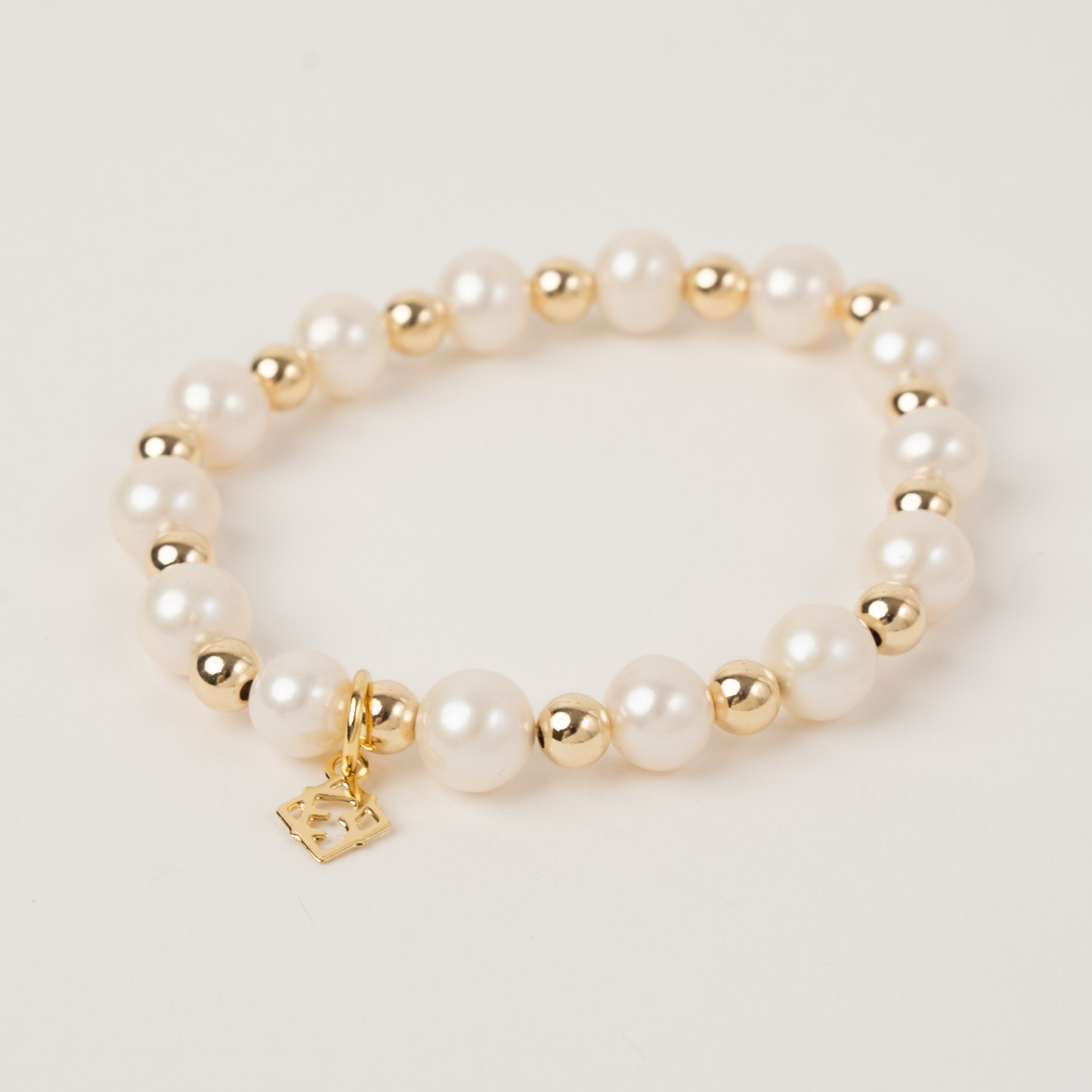 Pearl bracelet with gold accents on a light background