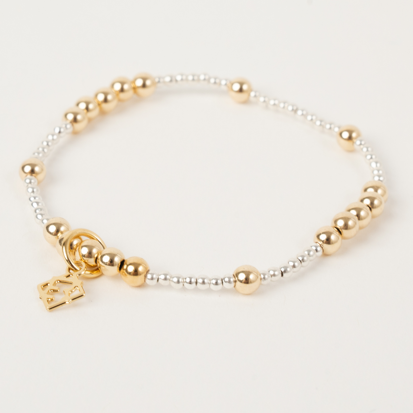 Bracelet with gold and silver beads on a white background