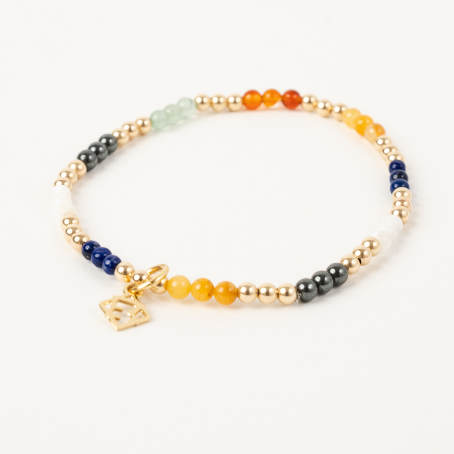Multicolored beaded bracelet with gold charm on a white background