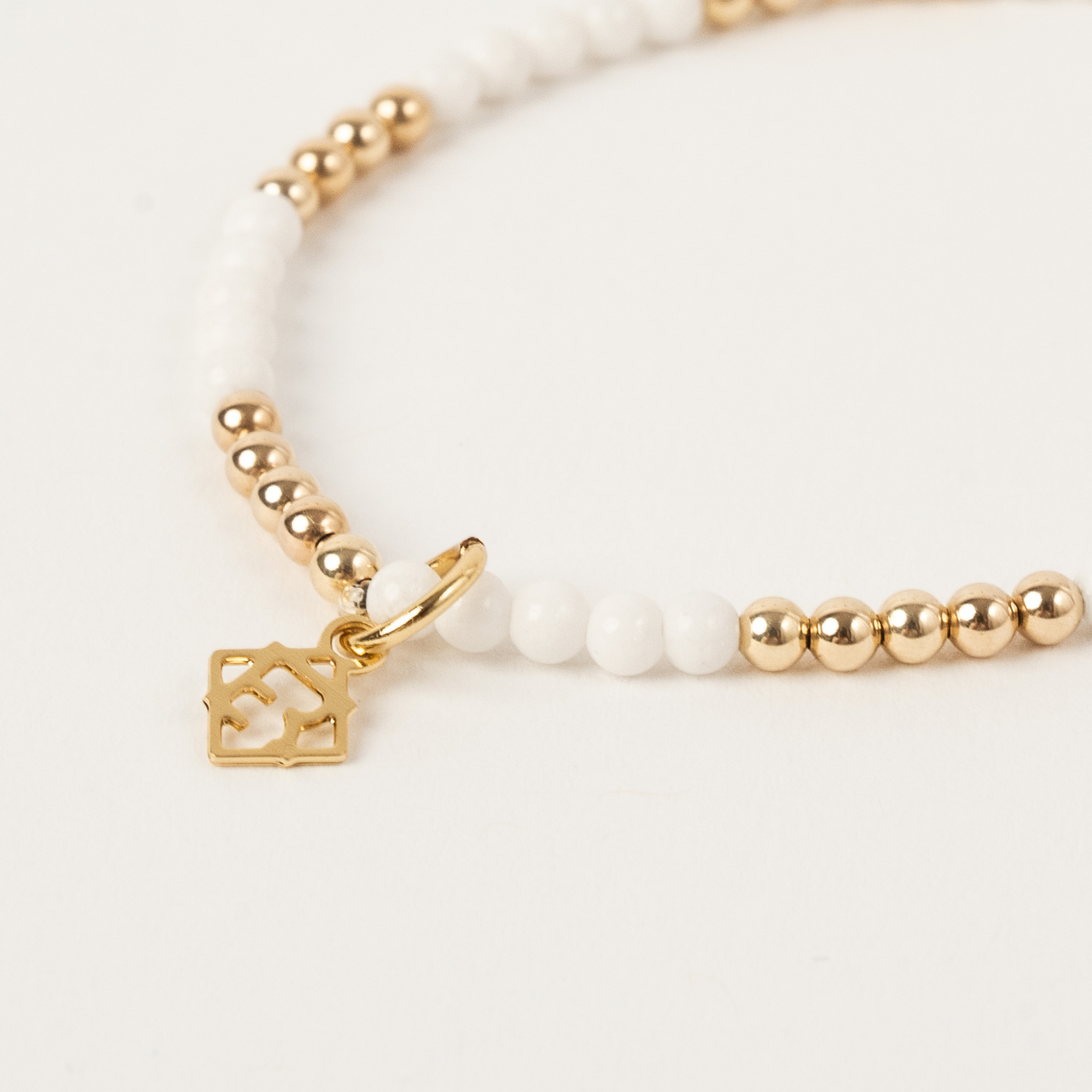 Gold and pearl bracelet on a white background