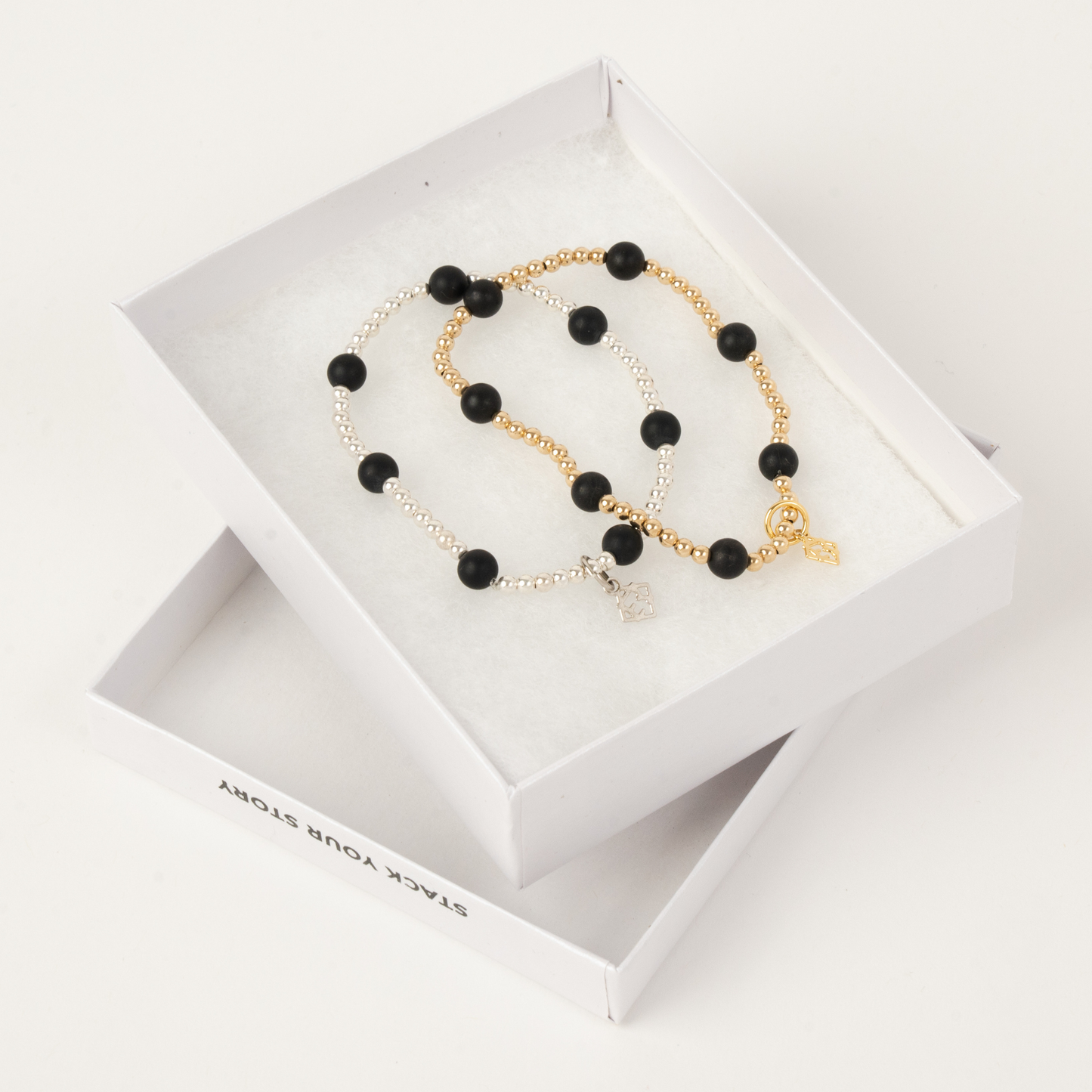 Black beaded necklace with gold chain in a white box