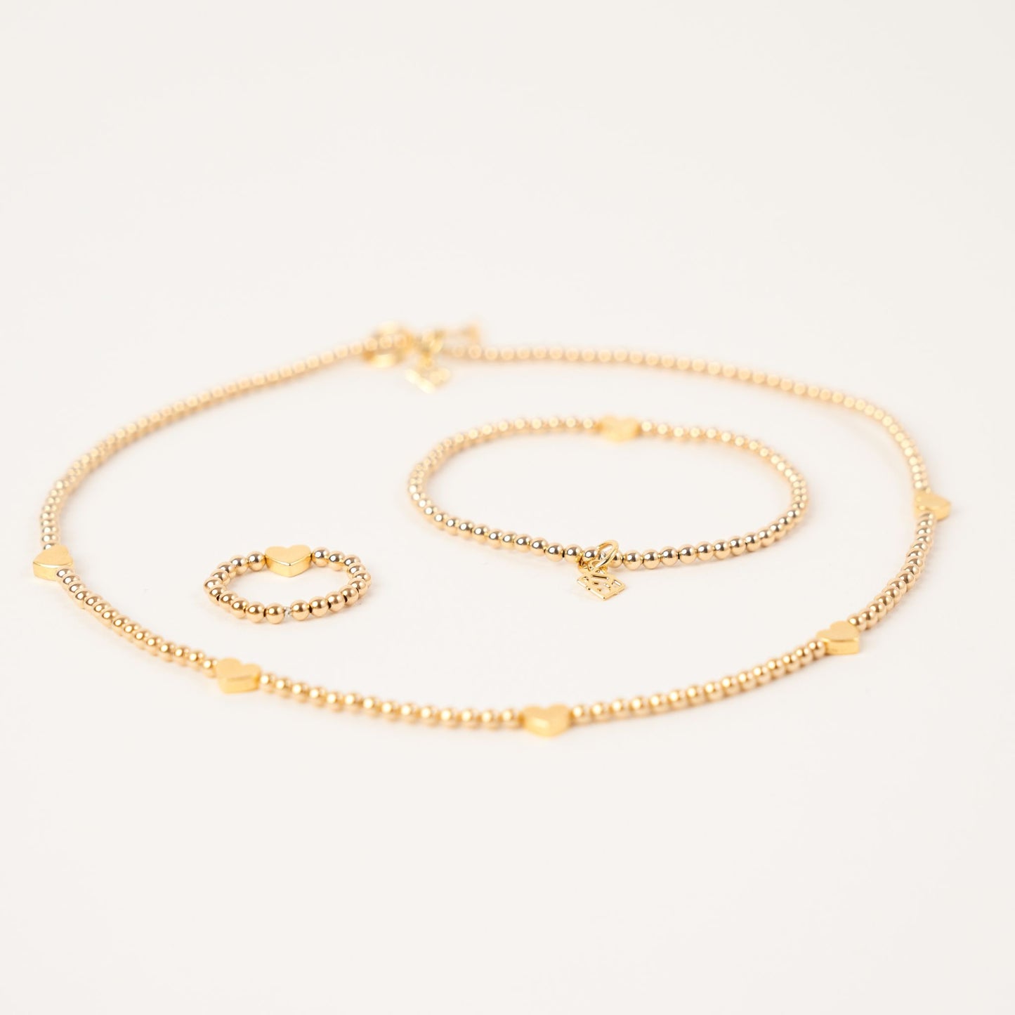 Set of gold jewelry on a light gray background