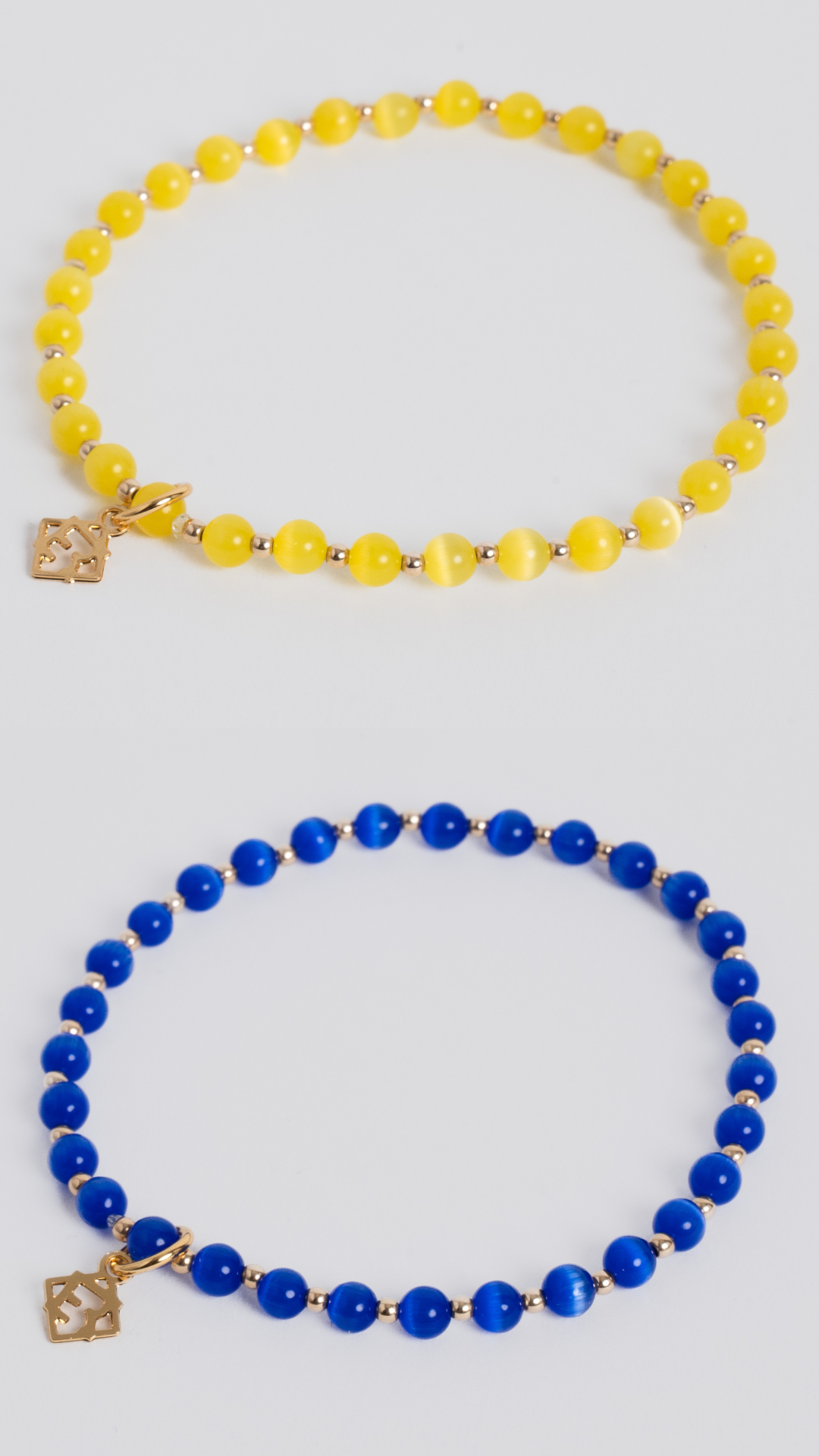 Two beaded stretch bracelets displayed on a light gray background. The top bracelet features translucent yellow beads with small gold spacer beads and a gold charm.