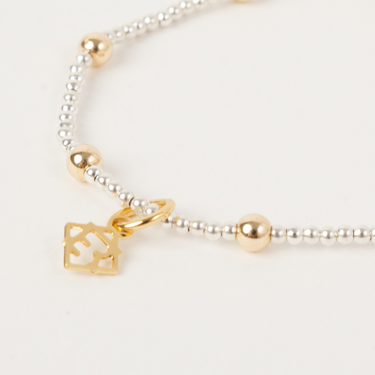 Close-up of the evenly spaced 14K gold-filled beads and ElyseRyan charm on the Clarity Single Bracelet