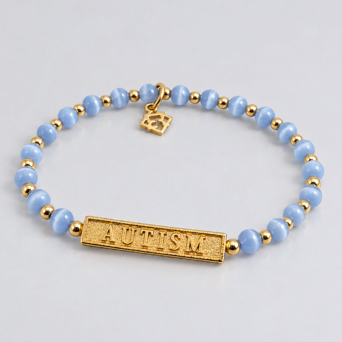 Autism Speaks bracelet with blue beads, gold accents and an engraved AUTISM bar
