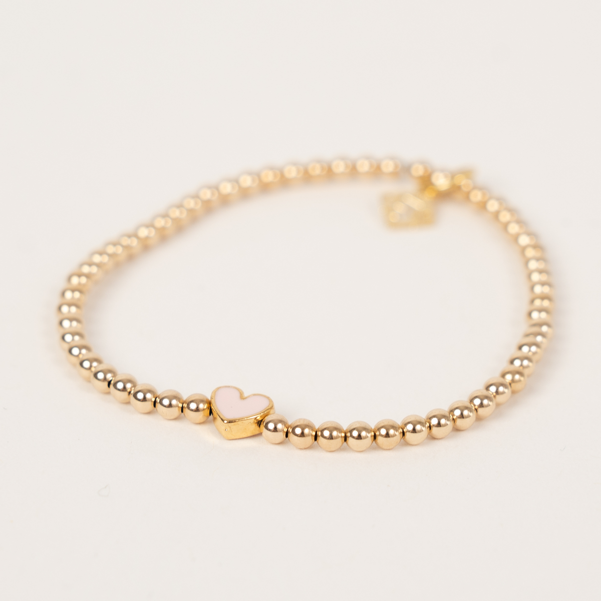 Blush Happy Heart Bracelet with 3mm 14K gold-filled beads, a blush pink enamel heart and signature ER charm