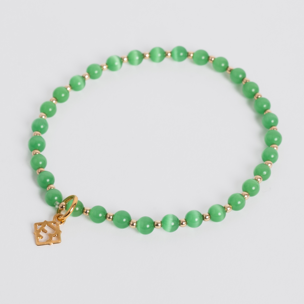 Evergreen Prism Bracelet with 4mm deep green cat’s-eye stones, 14K gold-filled beads and a golden ER charm