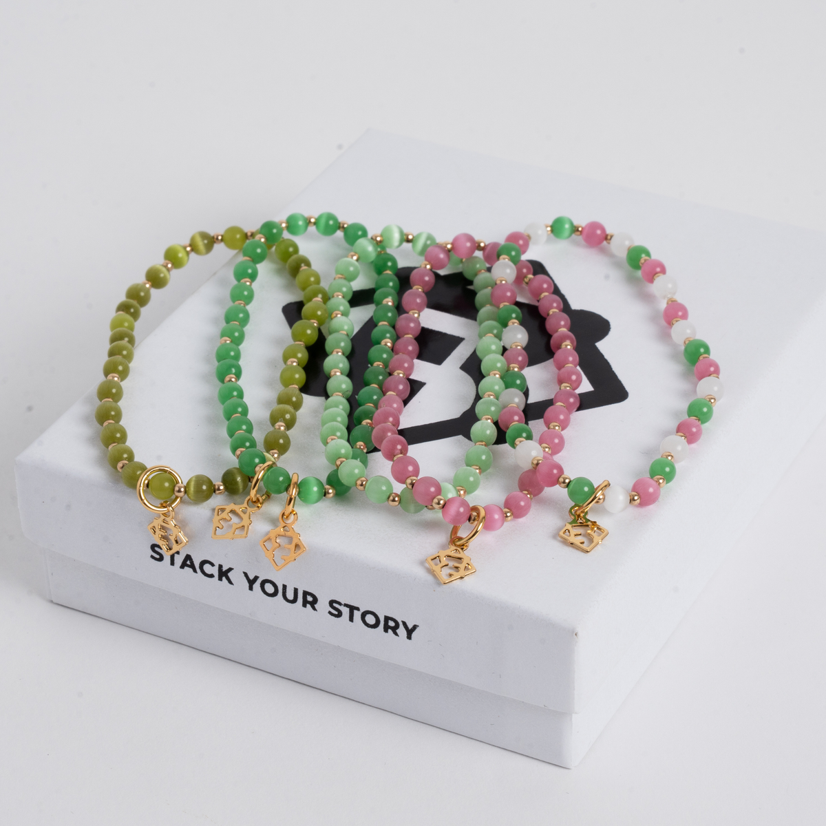 Close-up of five Green Prism bracelets with 4mm cat’s-eye stones, 14K gold-filled beads and golden ER charms