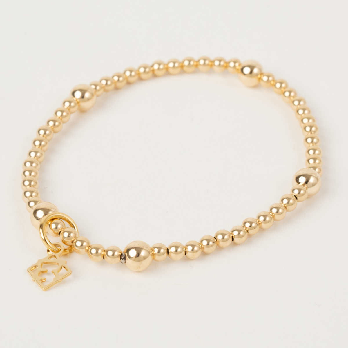 Lennon Gold Bracelet with alternating 3mm and 5mm 14K gold-filled beads and an ElyseRyan charm
