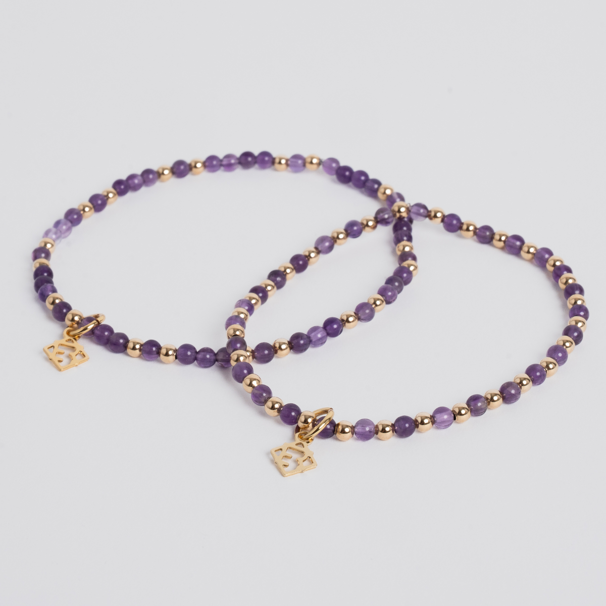Lilly Blissful Amethyst Bracelet Duo with 3mm purple amethyst beads, 3mm 14K gold-filled beads and golden ER charms