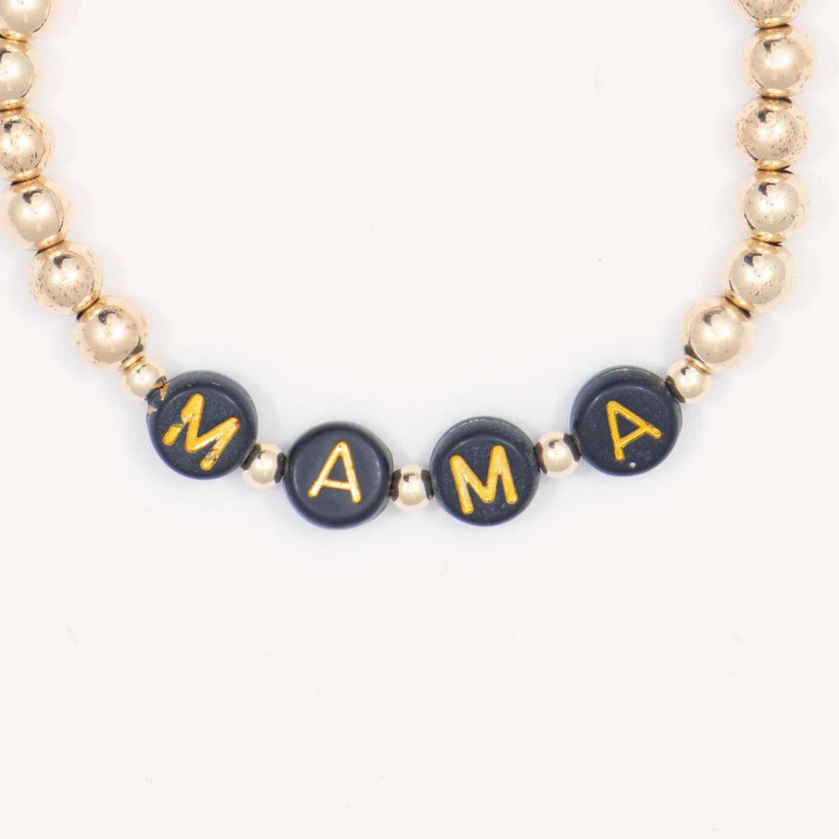 Close-up of black letter beads spelling MAMA on the 14K gold-filled Thoughtful bracelet