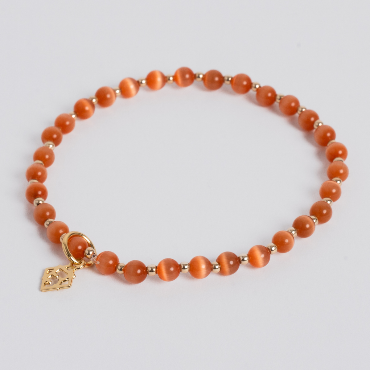 Orange Prism Bracelet with 4mm orange cat’s-eye stones, 14K gold-filled beads and a golden ER charm