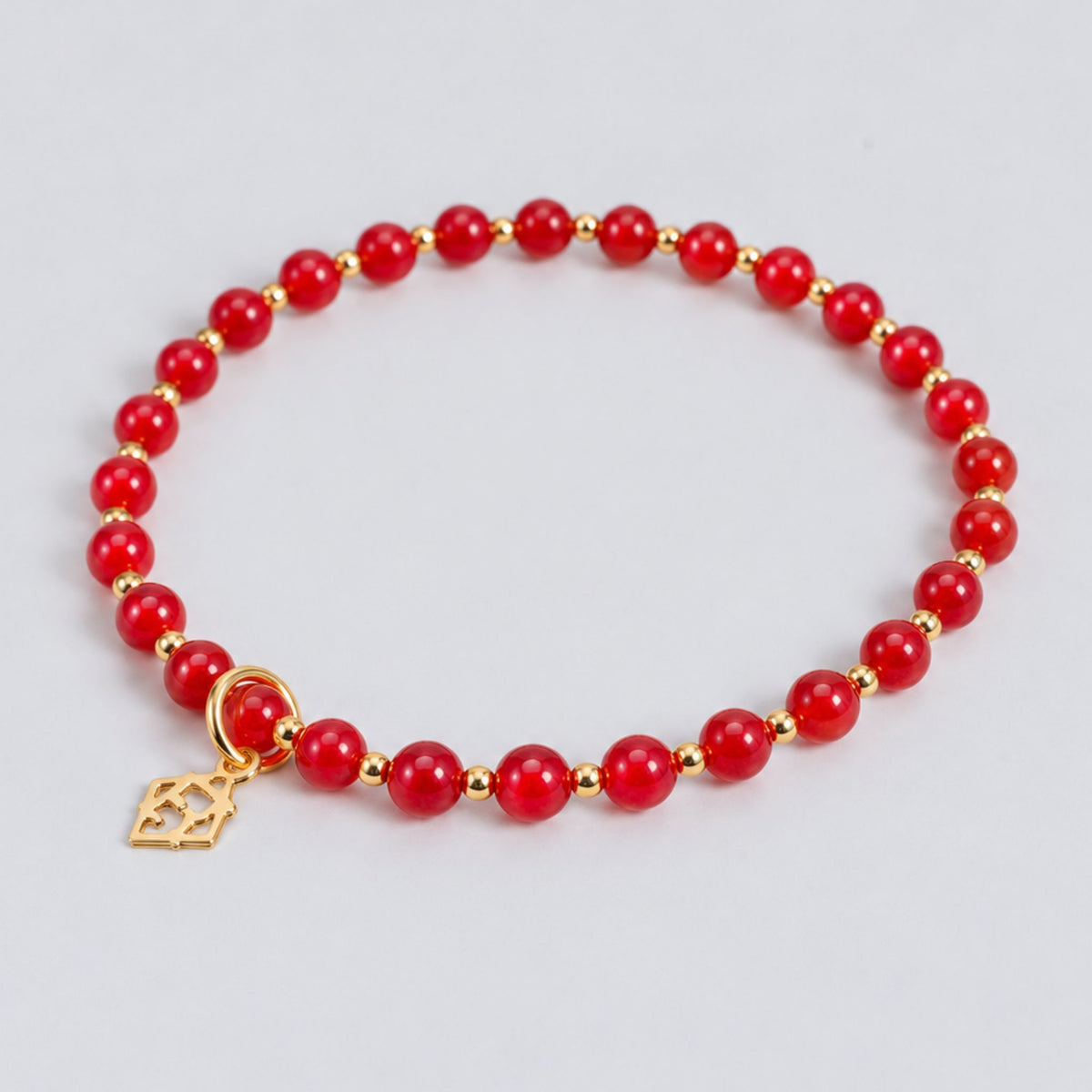 Prism Apple Red Bracelet with red cat’s-eye beads, 14K gold-filled accent beads and an ElyseRyan charm