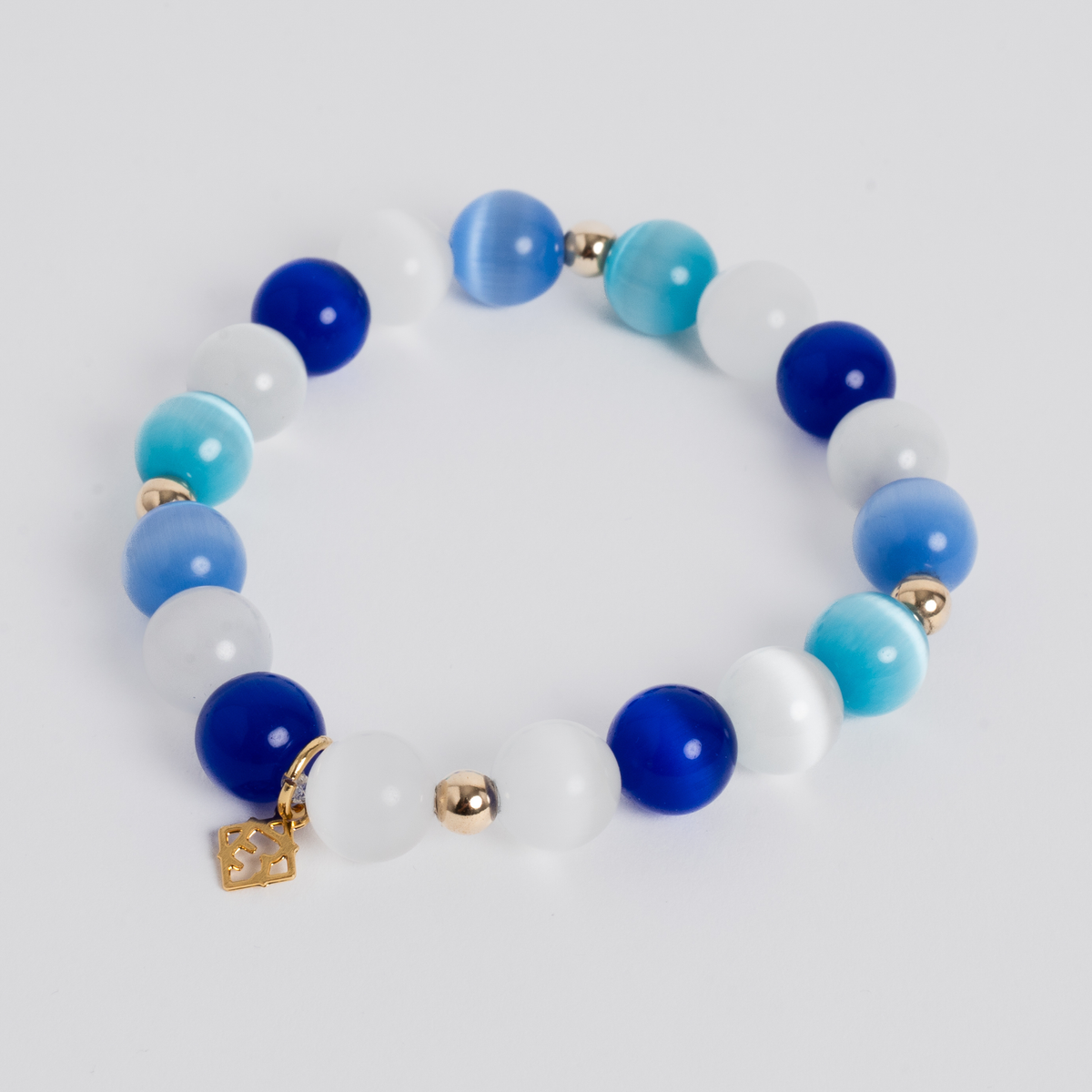 Prism Maxi Multi Blues stretch bracelet with 10mm blue and white cat’s-eye beads, 14K 5mm gold-filled accents and a signature golden ER charm