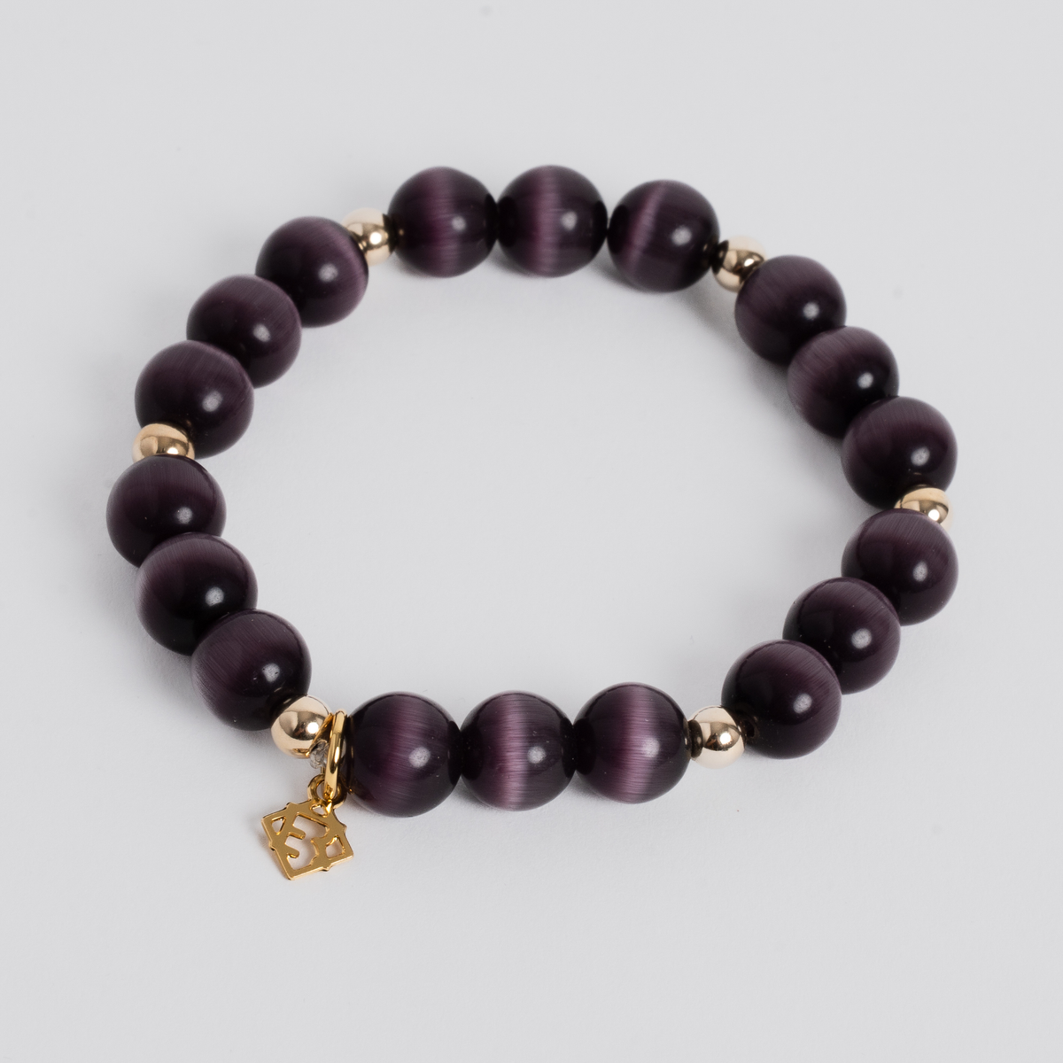 Prism Maxi Plum stretch bracelet with 10mm plum cat’s-eye beads, 5mm 14K gold-filled accents and a signature golden ER charm