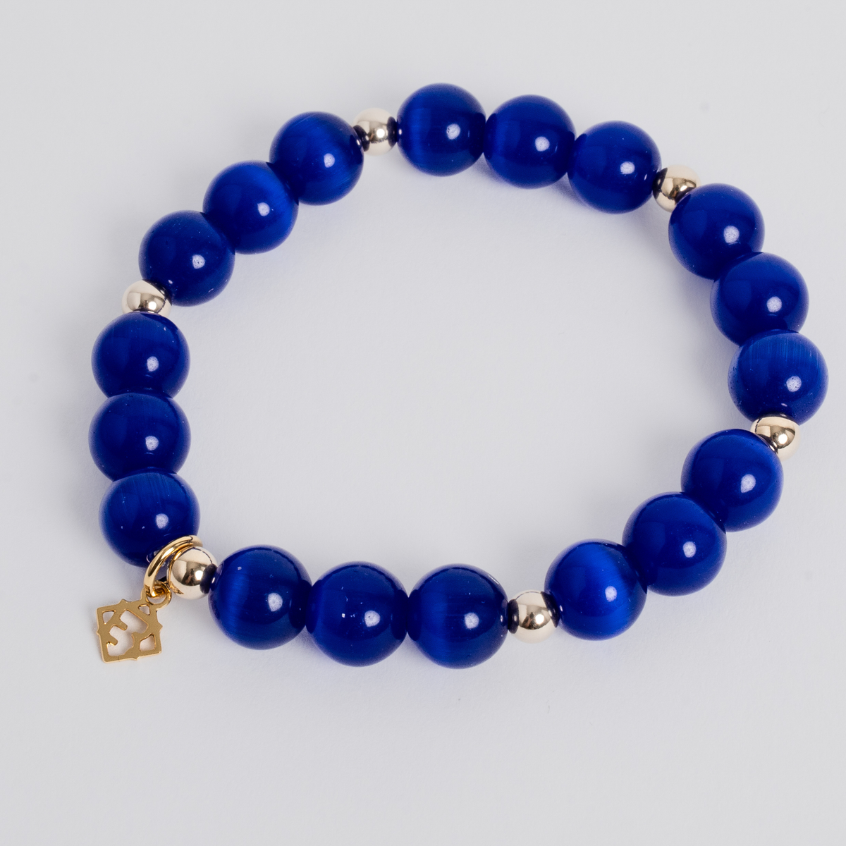 Prism Maxi Royal Blue stretch bracelet with 10mm cat’s-eye beads, 5mm 14K gold-filled accents and a signature golden ER charm