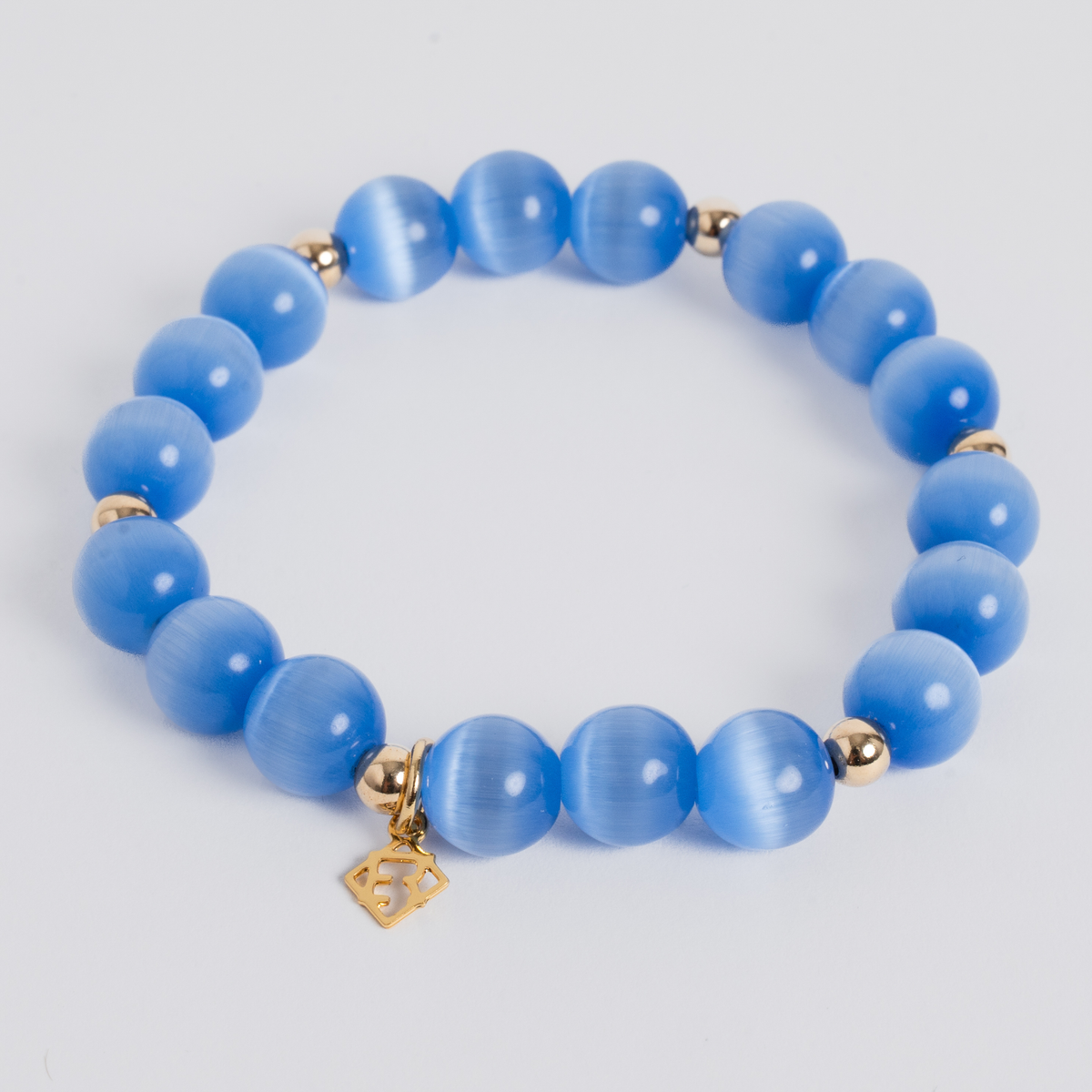 Prism Maxi Sky Blue stretch bracelet with 10mm cat’s-eye beads, 5mm 14K gold-filled accents and a signature golden ER charm