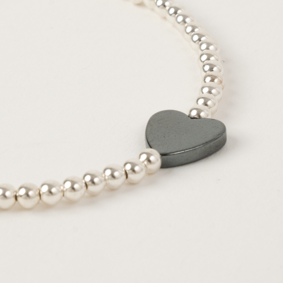 Close-up of the hematite heart and sterling silver beads on the Happy Heart Bracelet