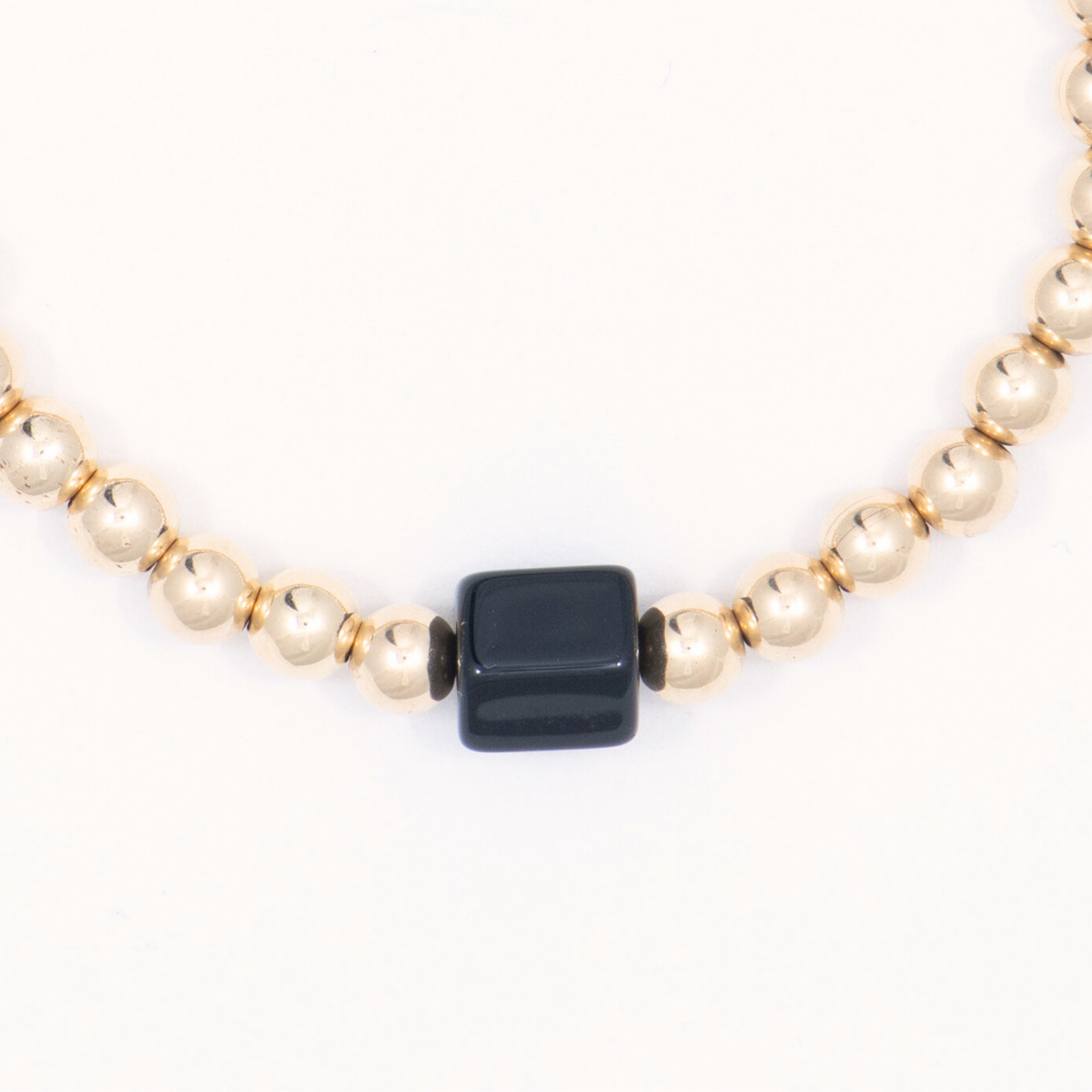 Close-up of the black onyx centerpiece and gold-filled beads on the Nugget Single Bracelet