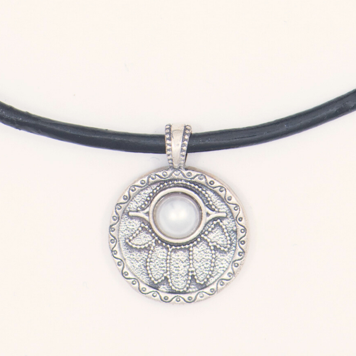 Close-up of the sterling silver Hamsa pendant with a freshwater pearl on the Pearl Society necklace
