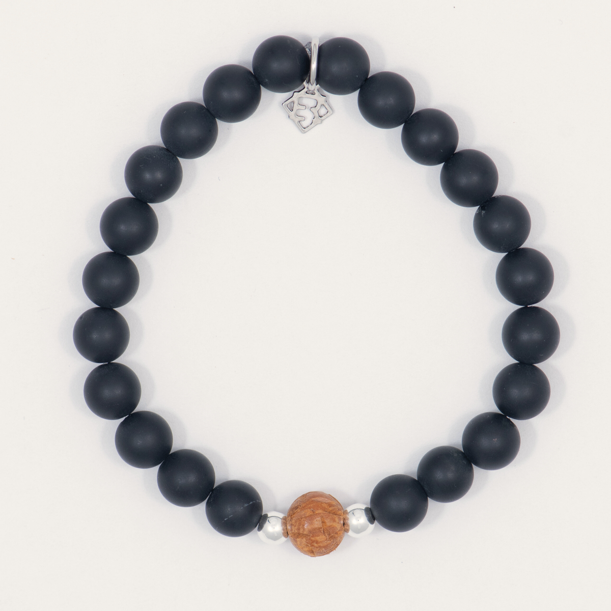 Resolute & Rooted men’s black onyx bracelet with a carved wood bead, sterling silver accents and a signature charm