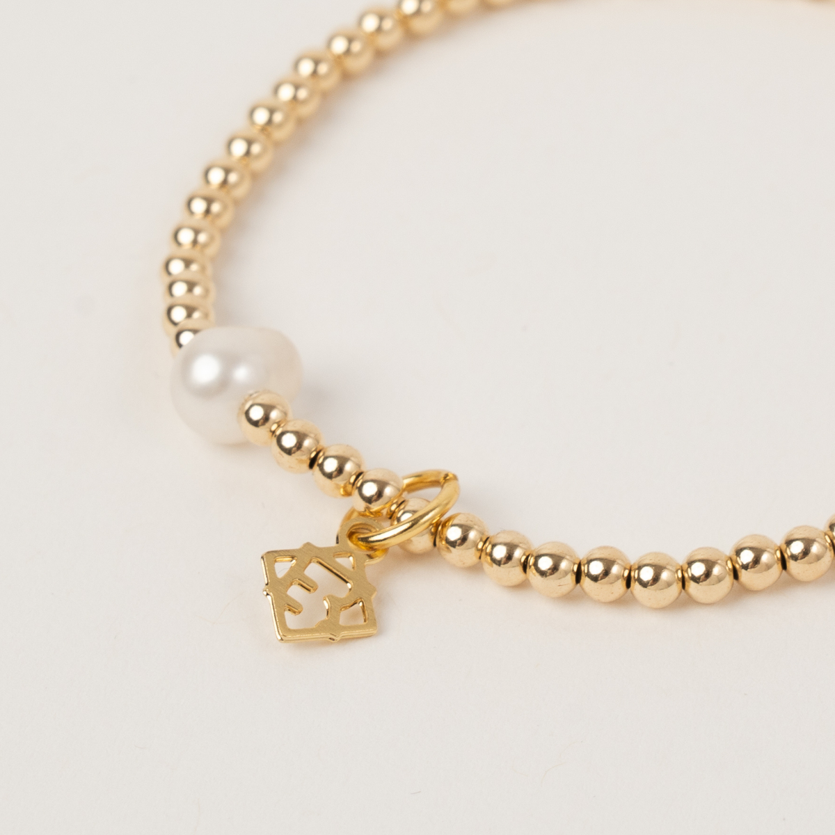 Close-up of the freshwater pearl, gold-filled beads and ElyseRyan charm on the Sincerity bracelet