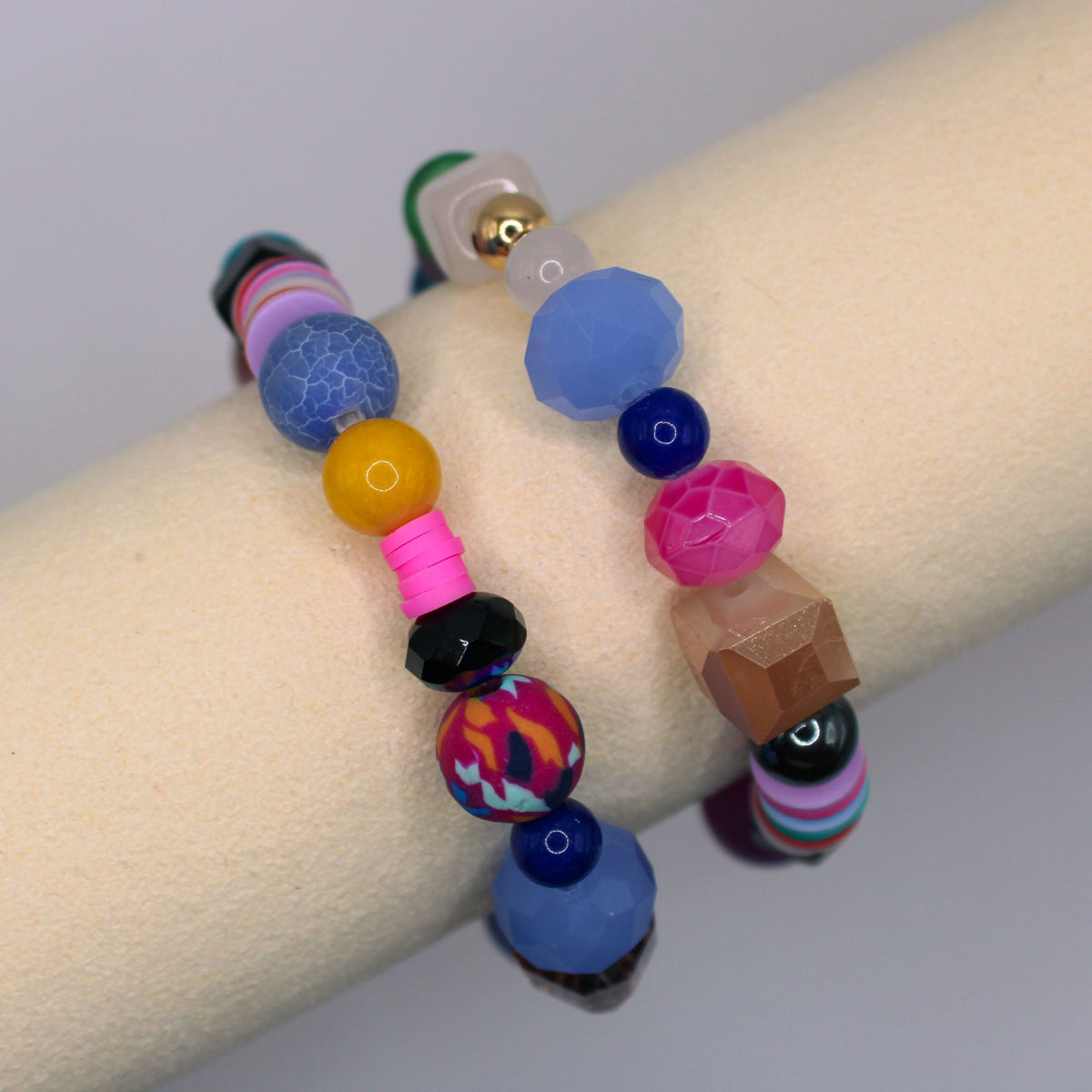 Close view of two SU2C WristRock bracelets with colorful beads in varied shapes and textures